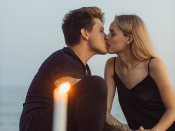 Horoskop: Frau und Mann küssen sich auf einer Decke