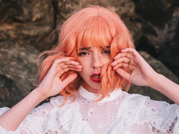 Frau mit rosa Haaren und Glitzer im Gesicht