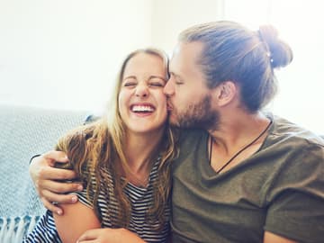 Wenn ein Mann eine Frau wirklich will: Mann küsst Frau auf Sofa