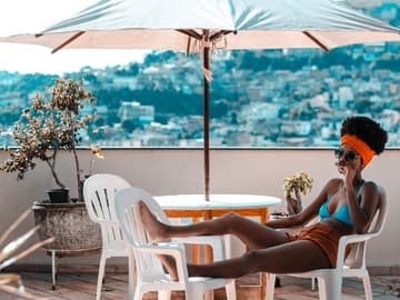 Frau liegt auf dem Balkon im Bikini
