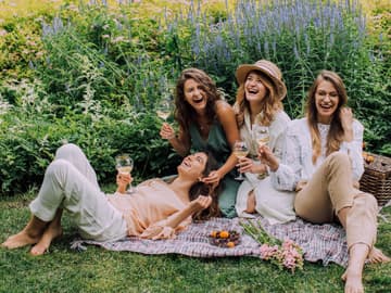 Horoskop: Vier Frauen mit Weinglas im Park