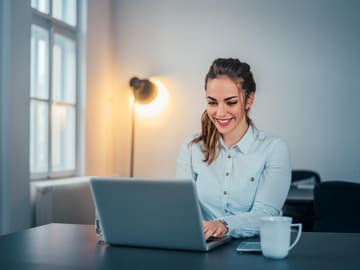 Junge Frau sitzt am Laptop