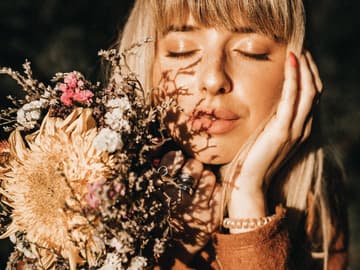 Horoskop der Woche: Frau mit Sonne im Gesicht