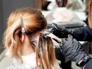 Frau färbt sich beim Friseur die Haare