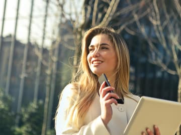 Eine junge Frau mit Smartphone in der Natur