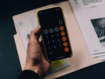 Eine Frau rechnet mit ihrem Handy