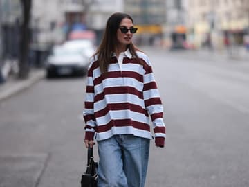 Eine Frau trägt ein gestreiftes Shirt und eine Jeans
