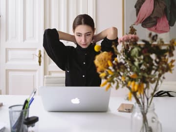 Eine junge Frau sitzt vor ihrem Laptop