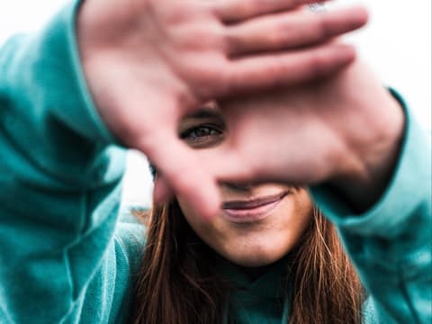 Mädchen hält die Hände vor das Gesicht