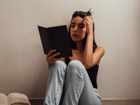 Bücher vor dem 18. Lebensjahr Mädchen sitzt auf dem Boden mit Büchern