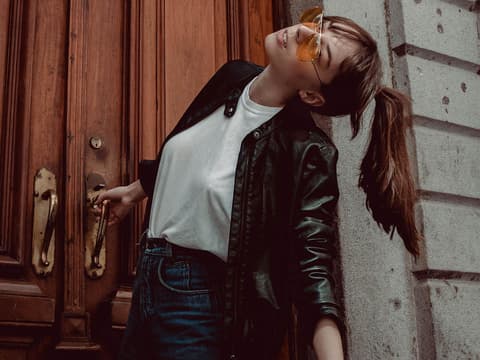 3 Basic Teile als Modetrend junge Frau in Jeans mit weißem Shirt und Lederjacke