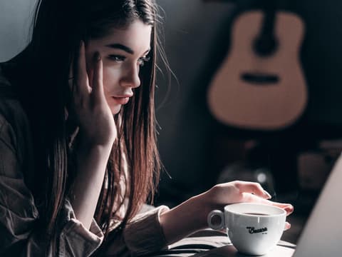 Benching Benching: Mädchen starrt in Laptop und hält eine Tasse in der Hand