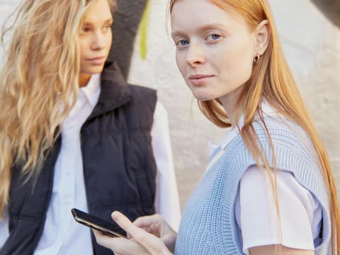 Coole Benutzernamen für dein Online-Profil Zwei junge Frauen mit einem Handy